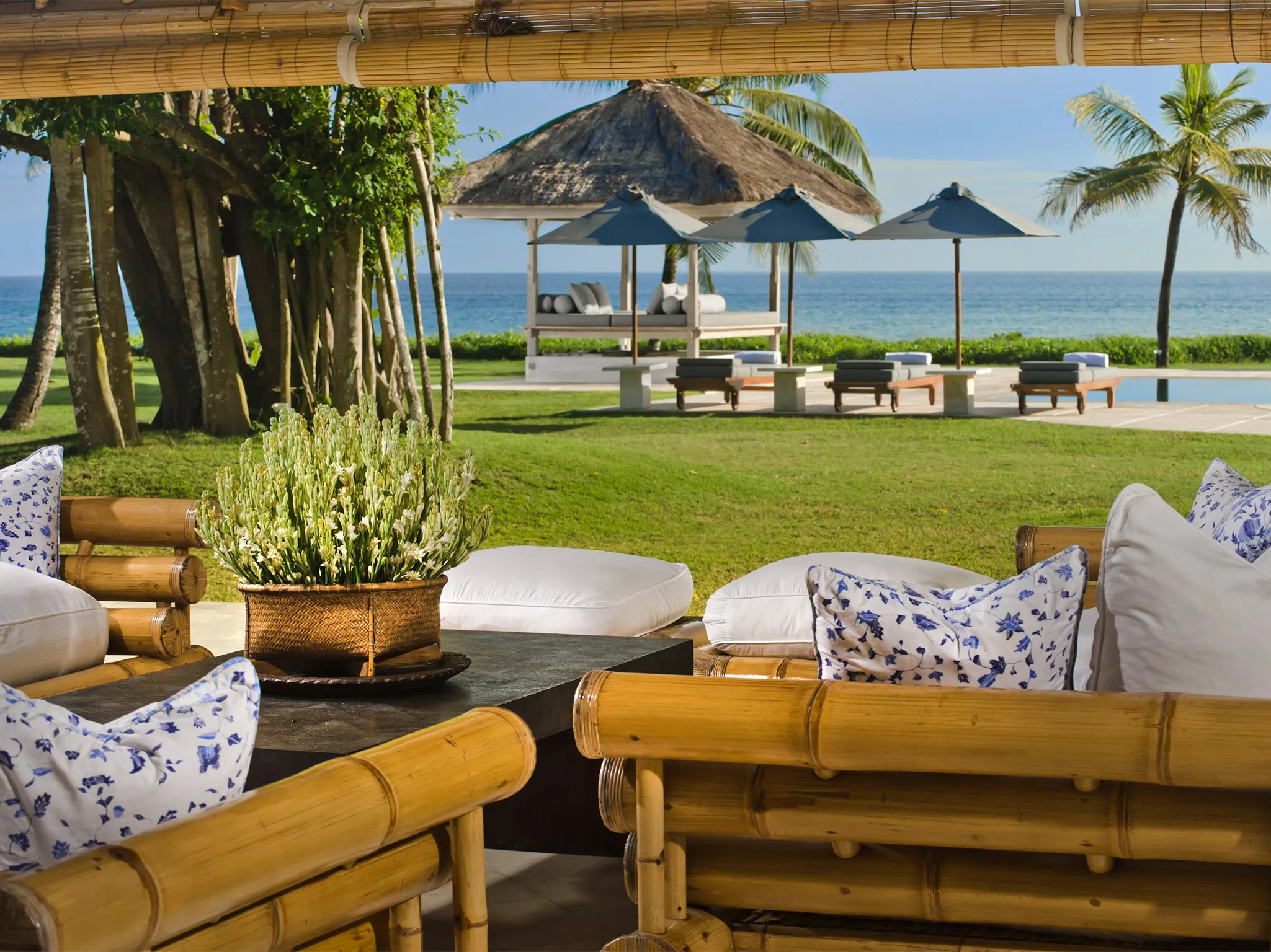 Atas Ombak - Living pavilion sofas with a view over the pool and sea beyond