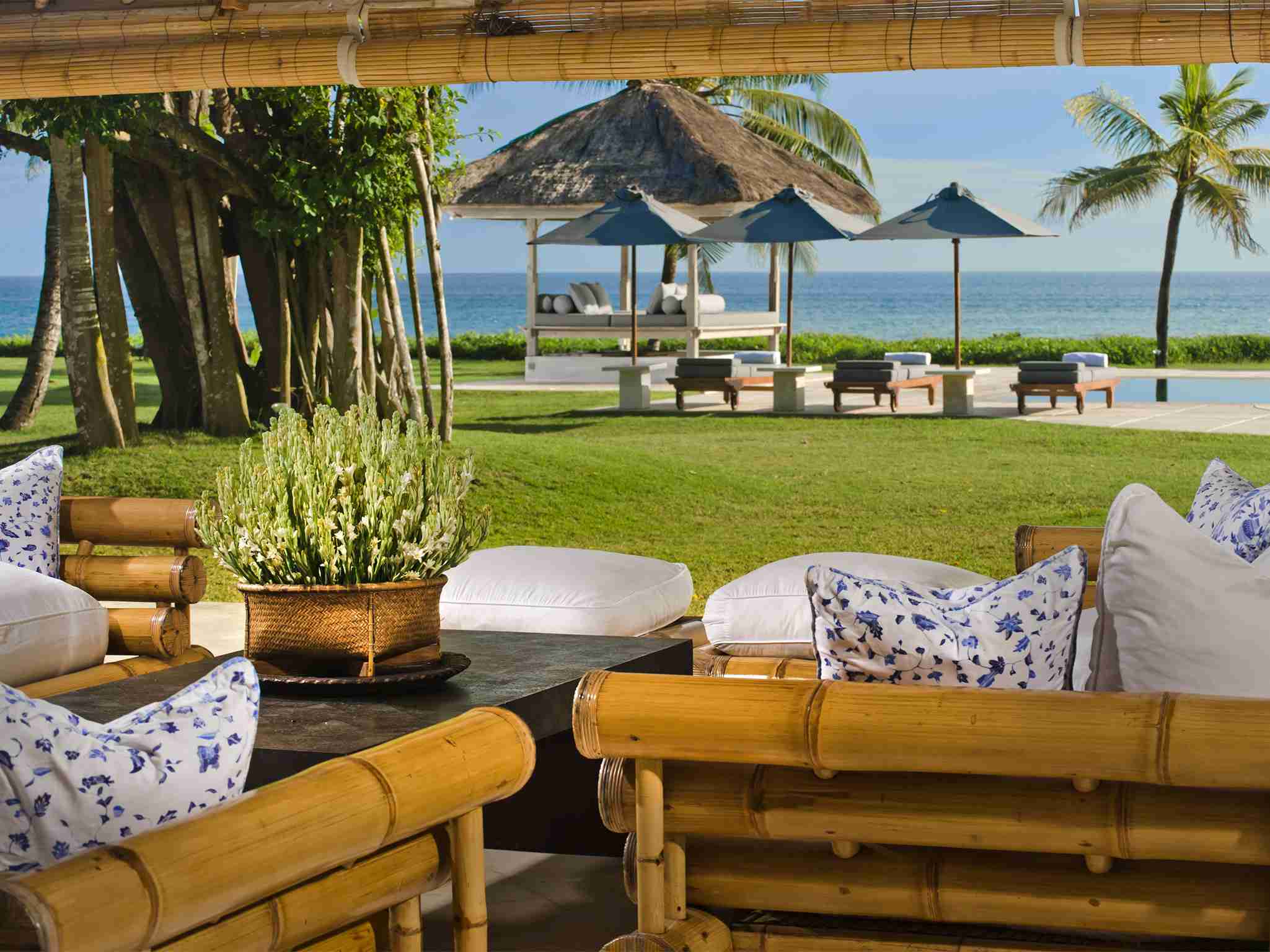 Atas Ombak - Living pavilion sofas with a view over the pool and sea beyond