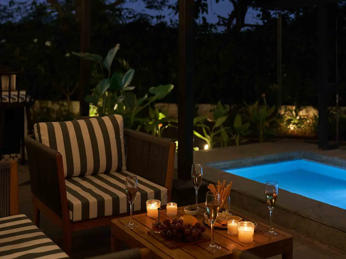 Poolside evening with candlelit table and garden lights - Sienna|Lohono Stays